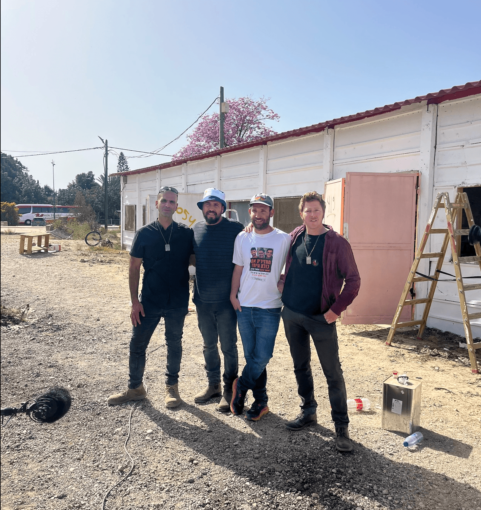 Four partners standing together at a rebuilding site in the Eshkol region