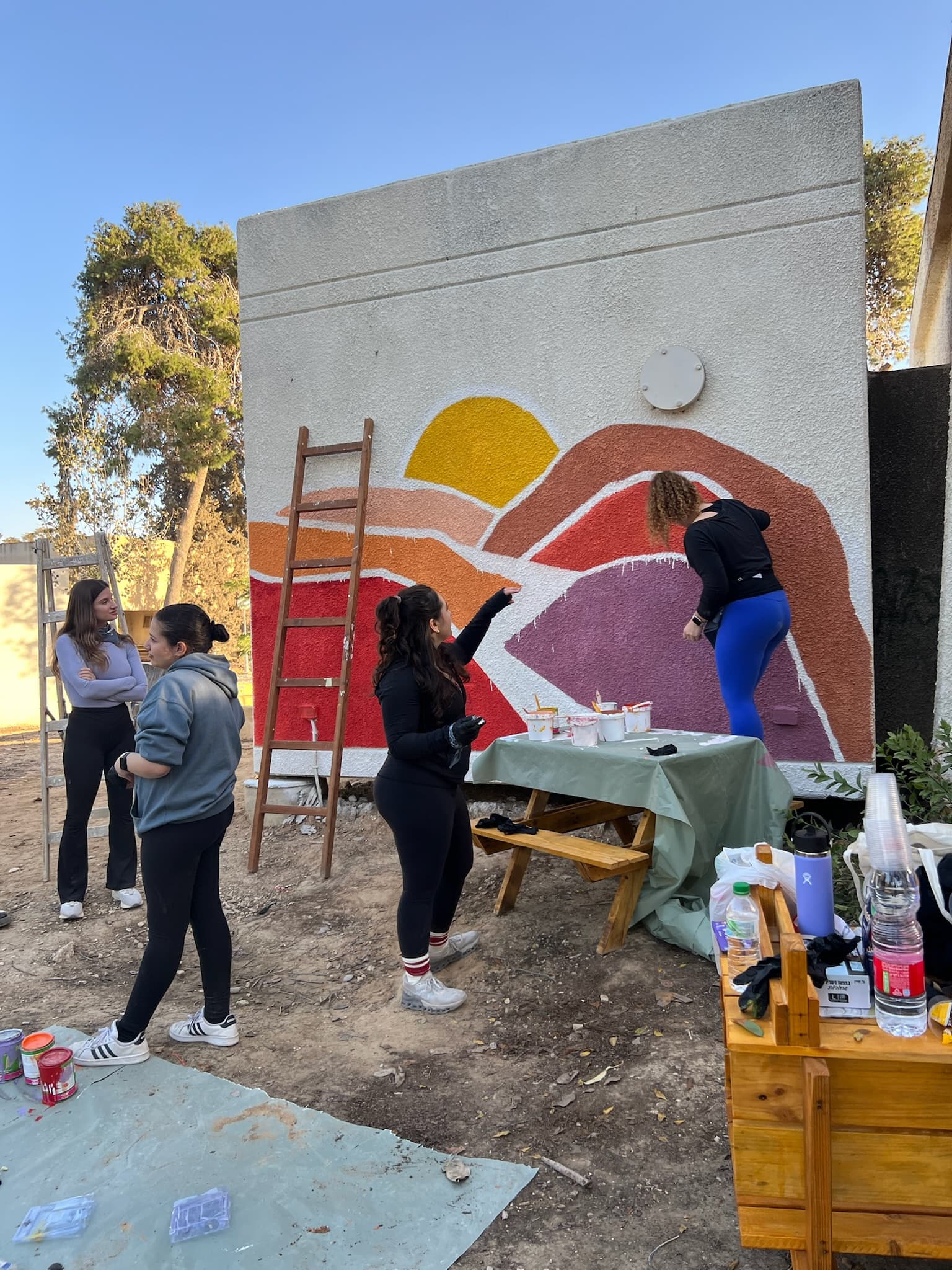 Volunteers painting a colorful mural at the kindergarten