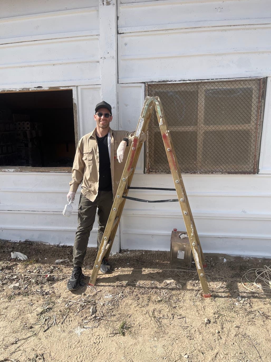 A volunteer painting the exterior of the Community Wine Bar